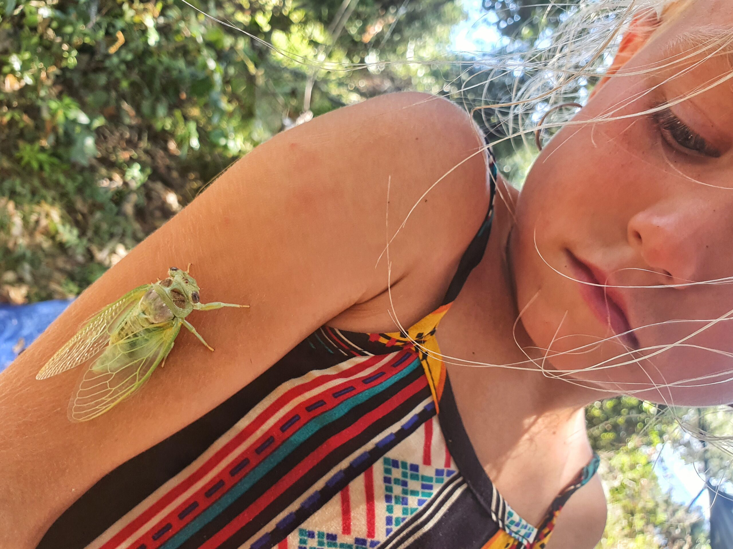 Emocje dziecka i autentyczna ciekawość świata: Dziewczynka z pasikonikiem na ramieniu jako symbol swobody i naturalnego rozwoju w The Place.