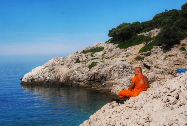 Bądź jak woda. Symbolika wody w Systemie Vedant: Przezroczysta kropla wody drążąca skałę w surowym, wulkanicznym krajobrazie jako metafora drogi do własnej Natury.