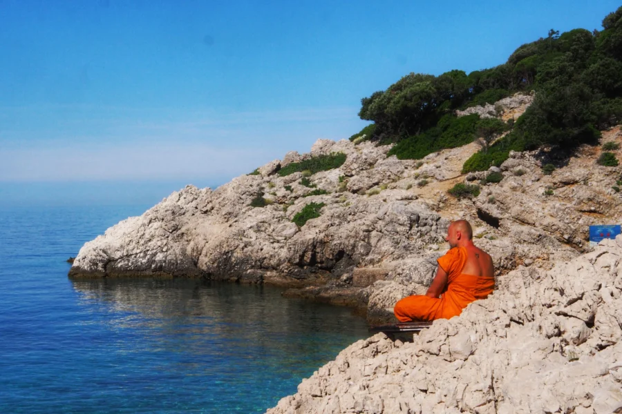 Bądź jak woda. Symbolika wody w Systemie Vedant: Przezroczysta kropla wody drążąca skałę w surowym, wulkanicznym krajobrazie jako metafora drogi do własnej Natury.