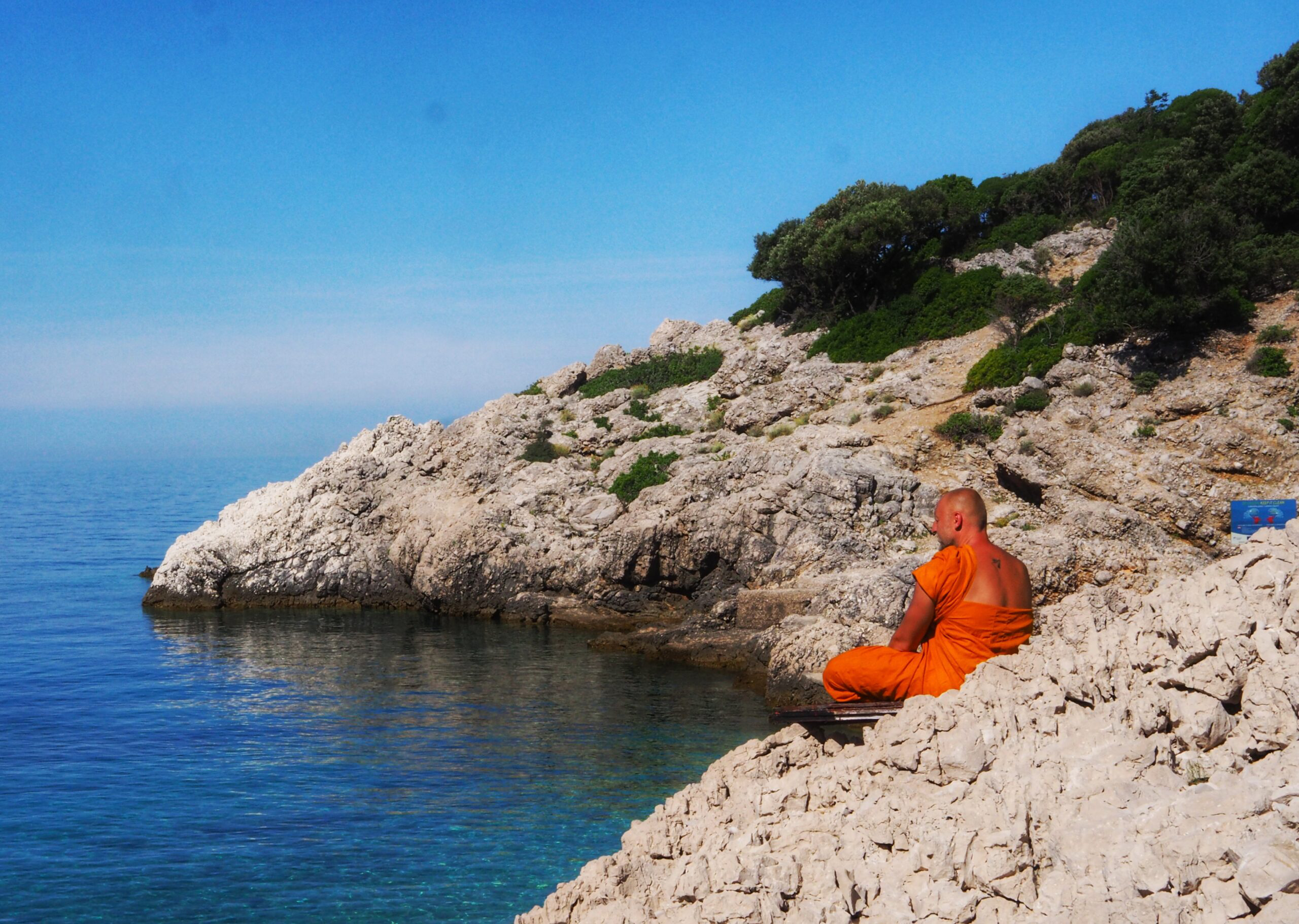 Bądź jak woda. Symbolika wody w Systemie Vedant: Przezroczysta kropla wody drążąca skałę w surowym, wulkanicznym krajobrazie jako metafora drogi do własnej Natury.