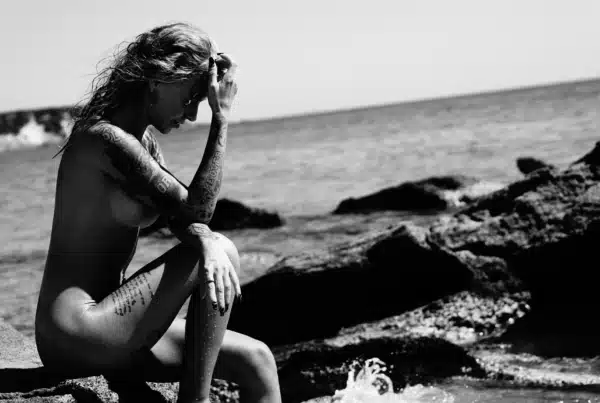 Rozgrzane słońcem skały nad brzegiem morza symbolizujące powrót do natury i autentyczny kontakt z ciałem.