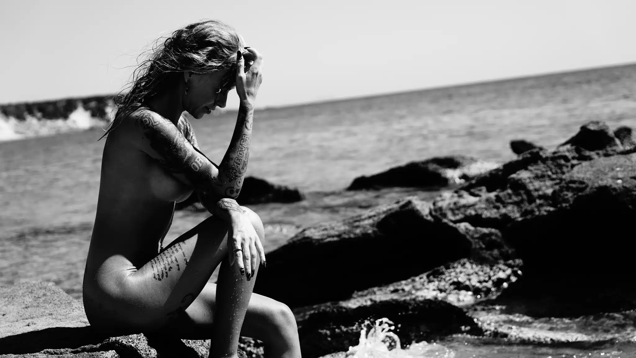 Rozgrzane słońcem skały nad brzegiem morza symbolizujące powrót do natury i autentyczny kontakt z ciałem.