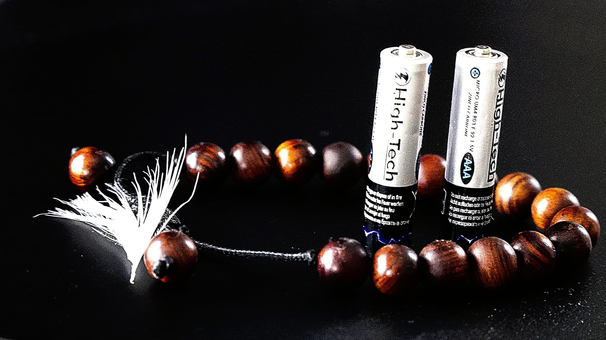 Atrybuty Trenera Integralnego - koraliki i pióro jako symbol integracji duchowości i materii.